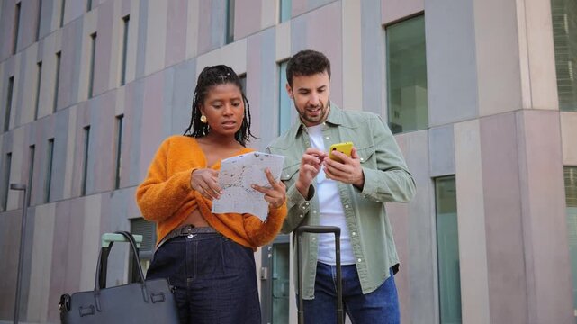 Happy and enthusiastic young couple joyfully discovering a new place, confidently navigating with a map and smartphone, enjoying their adventure together while taking in the sights around them.