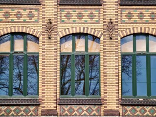 Decorative brick exterior. City building featuring ornate brick design and arched window details © Vladimir
