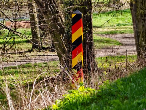 Tranquil countryside boundary sign beside railway lines covered in moss and blooming wildflowers
