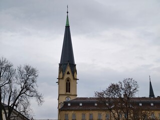 Serene winter morning featuring weathered church with towering steeple and cobbled pathway © Vladimir