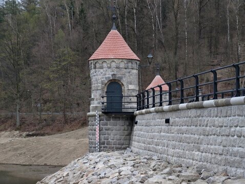 Serene riverside scene. Tranquil waterside setting featuring rock steps and sparse trees contrast