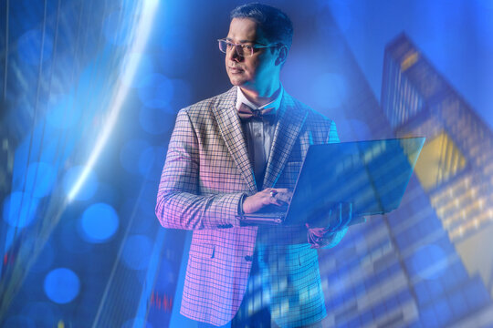 Financial consulting, Urban business. Stylish male professional analyzes data on laptop outdoors near modern office buildings, planning strategy, working remotely in evening city lights.
