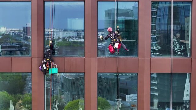Aerial Poland window washers high rise building zoom. Historical capital of Greater Poland. Academic, scientific, and cultural center. Metropolitan area with modern high rise business and apartments.