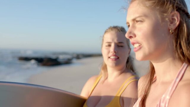 Two women discussing surf at beach, camera pulling closer, neon arcs sweeping over board for design