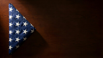 Obraz premium Triangular USA Flag Fold on Wooden Surface for Memorial Day Tribute