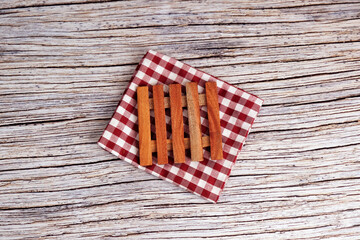 Obraz premium Mini Wooden pallets on checkered cloth. Rustic table beneath provides textured backdrop. Warm tones suggest cozy, vintage charm. Perfect for kitchen, bathroom, or home decor scenes