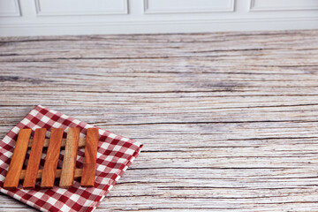Obraz premium Mini Wooden pallets on checkered cloth. Rustic table beneath provides textured backdrop. Warm tones suggest cozy, vintage charm. Perfect for kitchen, bathroom, or home decor scenes