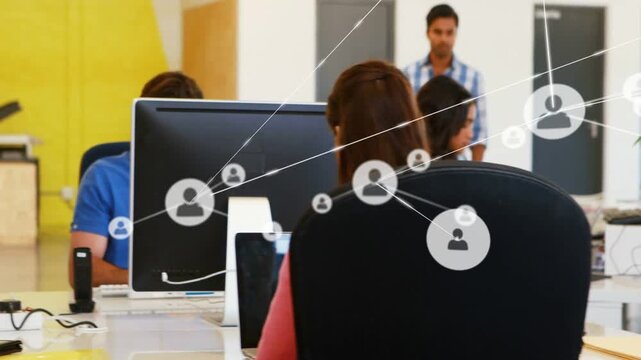 Worker in red top typing, initiating network icons appearing and spreading, showing collaboration