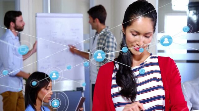 Woman tapping smartwatch in business meeting, making network icons linking tablet flipchart laptop