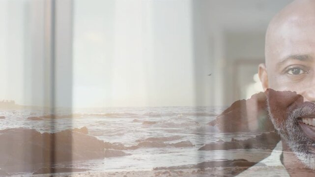 Mature man reacting to cue, smiling and laughing with seascape and vertical bands ads