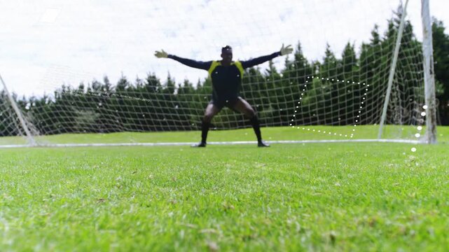 Sports attacker sliding intercepting low shot from right, preventing goal, dotted path tracing ball