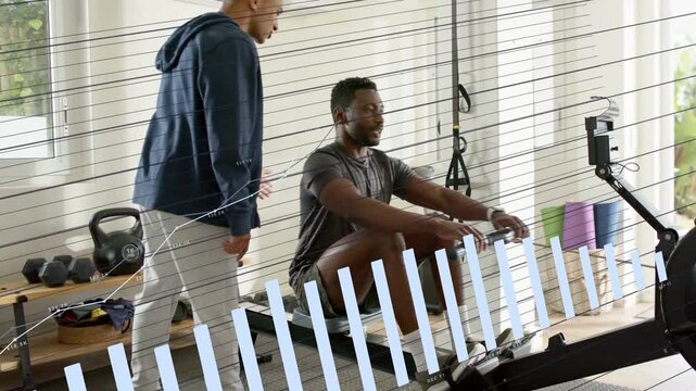 Coach pointing, adjusting grip, trainee starting rowing for training, monitor animating metrics