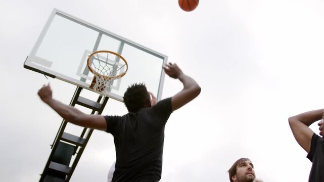 Sports player raising ball trying to score, turquoise sweeping over men, ball arcing through net