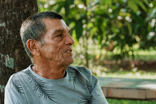 Older man looking away outdoors with thoughtful expression