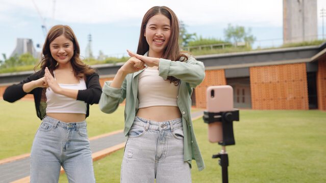 Gen z vlogger influencer asia teen girl trending relax smile moving dance at city park street record on IG reel tiktok instagram app young youtuber play fun joy selfie post show share viral vlog video