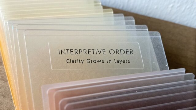 Layers of Colorful Transparent Cards with Inspirational Quote about Interpretive Order and Clarity in Design