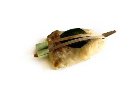 Jadah Manten, traditional Javanese snack made of sticky rice filled with meat, wrapped in egg crepe and clamped with bamboo, isolated on white background. Authentic Indonesian culinary heritage.