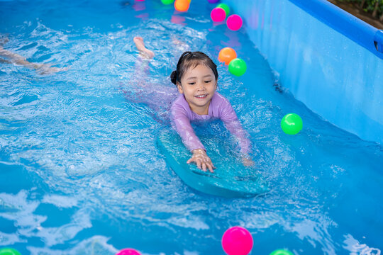 preschool child girl playing in swimming pool in backyard