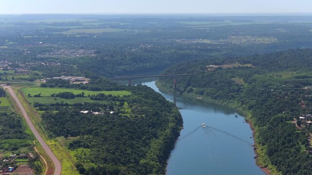 Aerial drone view looking down at the Tancredo Neves Bridge crossing the Iguazu River between Argentina and Brazil.