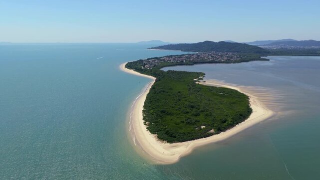Aerial view of Praia da Daniela peninsula with white sand shoreline and calm blue ocean waters.