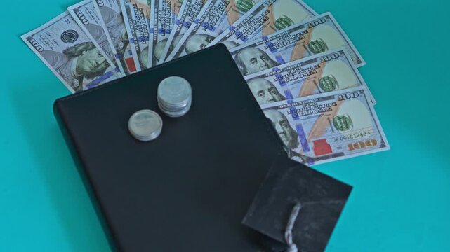 Educational funding concept with cash fanning out like sun behind student cap and coin stacks