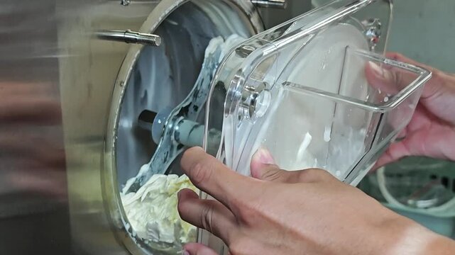 Ice cream maker machine. Ice cream falls into container.