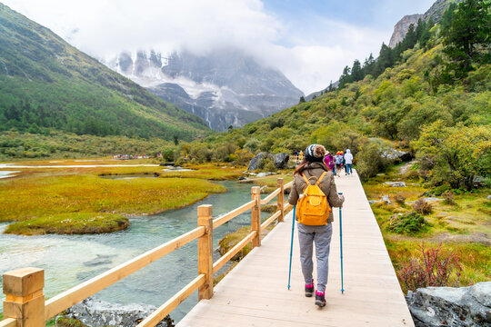 Young female hiker with trekking pole hiking and enjoying the beautiful mountain views, Freedom, exploration and outdoor lifestyle