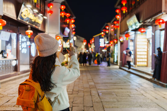 Young woman tourist taking pictures of the Shantang Street, a famous historic street and canal district in Suzhou, China