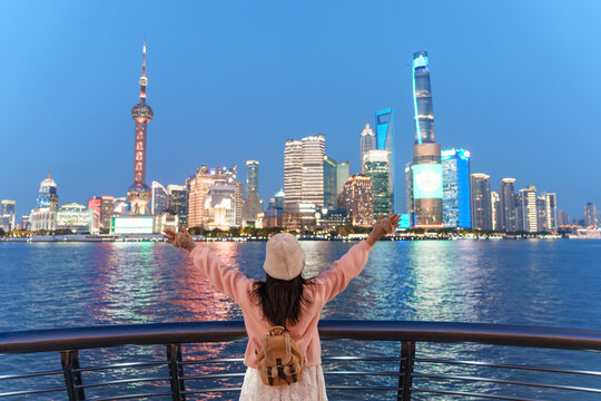 Female tourist enjoying the night view of Shanghai skyline at The Bund, China