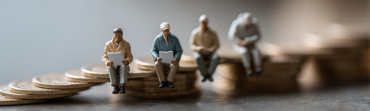 Retirement Planning: Miniature figurines representing individuals are seen seated atop stacks of coins that ascend like stairs, symbolizing retirement savings, financial security.