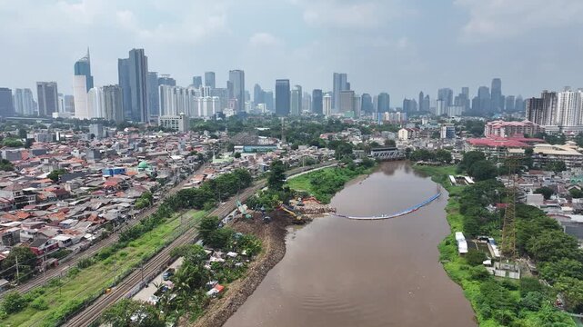 Aerial view The blue and yellow excavator is working to dig and clean the river from mud and rubbish, removing it to the edge of the river middle city