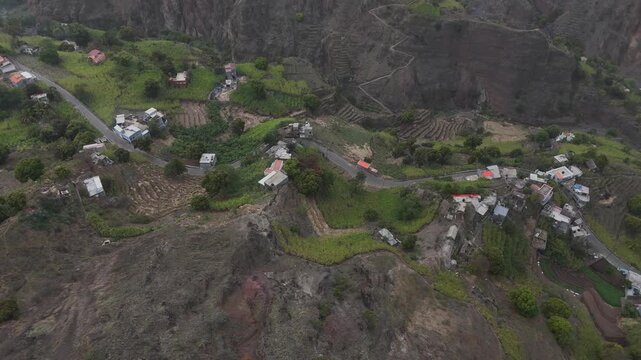 aerial view of small white dwellings scattered across the terraced green mountains of Santo Antao, Cabo Verde. Peaceful rural lifestyle in the heart of the Macaronesian islands