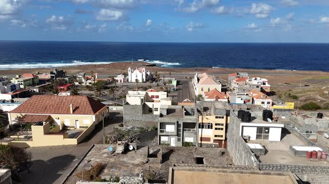 Cinematic aerial shot of Ponta Do Sol in Santo Antao, Cabo Verde. Drone view of the coastal town nestled between the Atlantic Ocean and the dramatic volcanic cliffs of the island