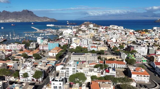 Wide aerial cityscape skyline view of Mindelo harbor and city, Sao Vicente. Capturing the maritime activity, the bay, and the colorful city sprawl under the bright sun of Cabo Verde