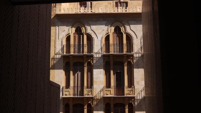 A framed view of traditional Levantine architecture in downtown Beirut. Elegant stone facade featuring triple-arched windows and wrought iron balconies, showcasing Lebanon's historic urban heritage