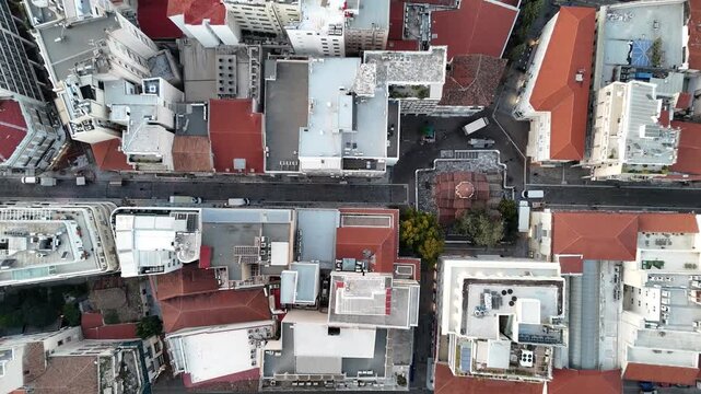 Top-down aerial perspective showing the geometric patterns of rooftops and streets in Athens, Greece. A detailed drone shot of the dense urban fabric of the Greek capital