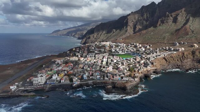 Aerial drone view of Ponta do Sol town on the rugged coastline of Santo Antao, Cape Verde. Coastal village situated on a volcanic peninsula with crashing Atlantic waves and steep mountains