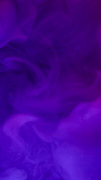 Vertical video. Explosion mist. Neon paint fog. Defocused purple blue pink color shiny rainbow water art texture glitter haze spreading particles on abstract background.