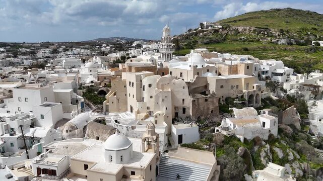 High angle aerial view of a traditional hillside village in Santorini, Greece. The white cycladic architecture and narrow paths create a unique urban pattern on the rocky terrain