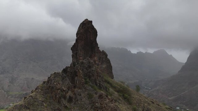 Dramatic aerial shot of a sharp volcanic pinnacle rising above the misty clouds in Santo Antao, Cabo Verde