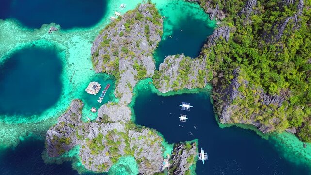 Coron Twin Lagoon showing stunning limestone formations, turquoise waters, and lush green vegetation on a sunny day. Marvelous aerial view drone camera pointing down