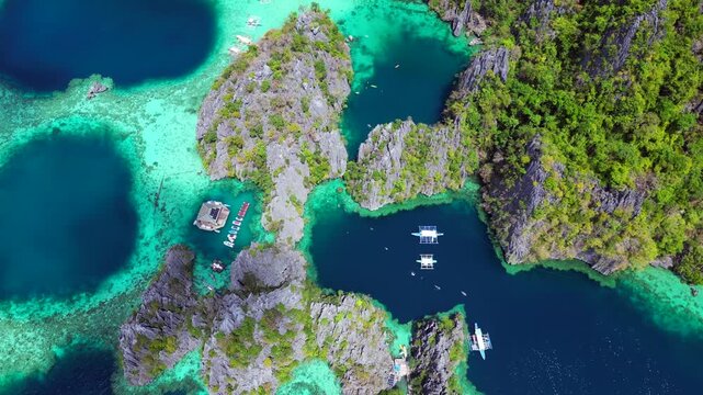 Coron Twin Lagoon showing stunning limestone formations, turquoise waters, and lush green vegetation on a sunny day. Brilliant aerial view drone camera pointing down