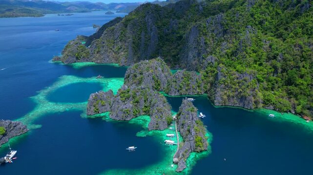 time lapse Philippines Palawan region seascape with clear turquoise water, limestone cliffs, green vegetation, and traditional boats. Nice aerial view fly reverse panorama drone