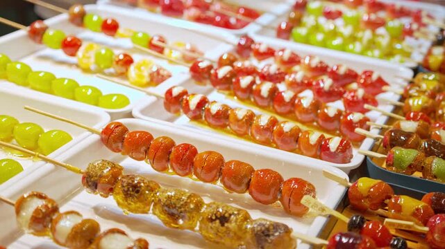 Traditional Chinese candied fruit snacks, known as Tanghulu at street food market.