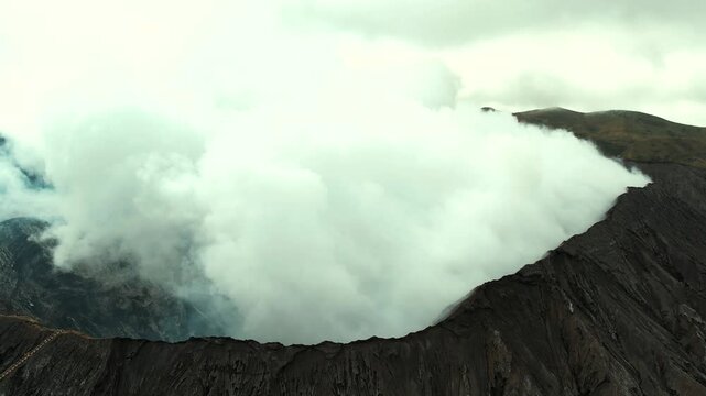 Drone overview of massive white plume rising from Mount Bromo crater, East Java, Indonesia