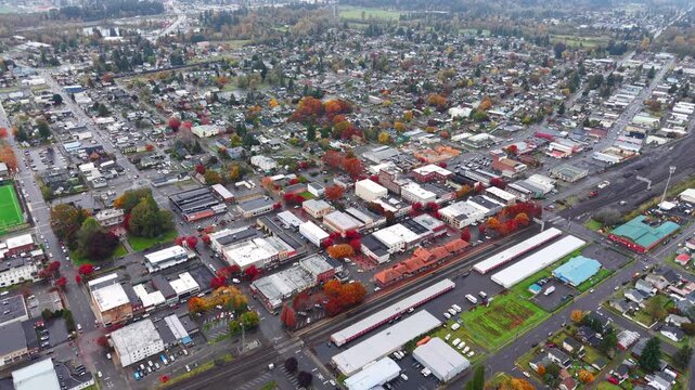 Aerial drone shot over Centralia city streets and houses at sunset during autumn with fall foliage
