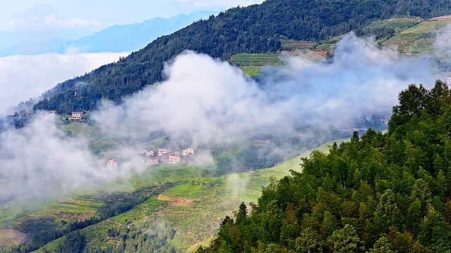 Misty mountain landscape with traditional village houses in a valley in Guilin, China
