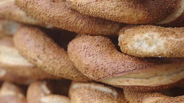 Fresh turkish simits stacked high at the bakery on a busy morning