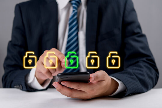 Businessman using smartphone glowing neon padlock icons. Digital network cybersecurity data protection privacy concept. Secure mobile banking connection.