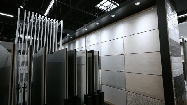 Element of Modern tile showroom interior with large size ceramic and porcelain slabs displayed in vertical racks. Wide view shot